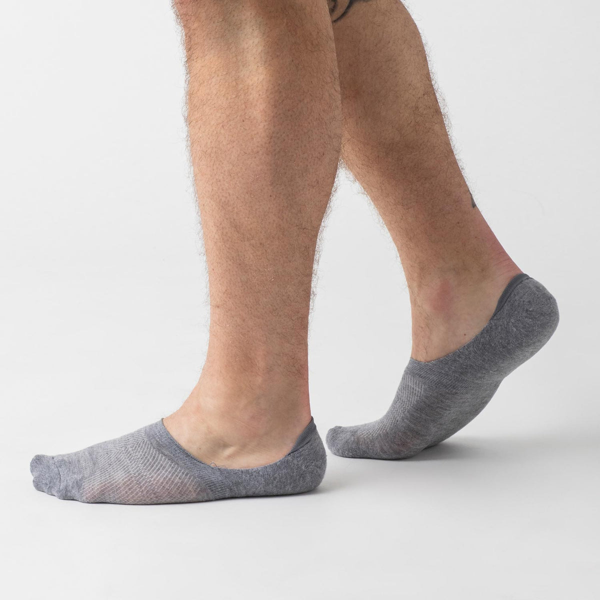 Heather Gray Never Show Socks on feet, low-cut, studio setting.