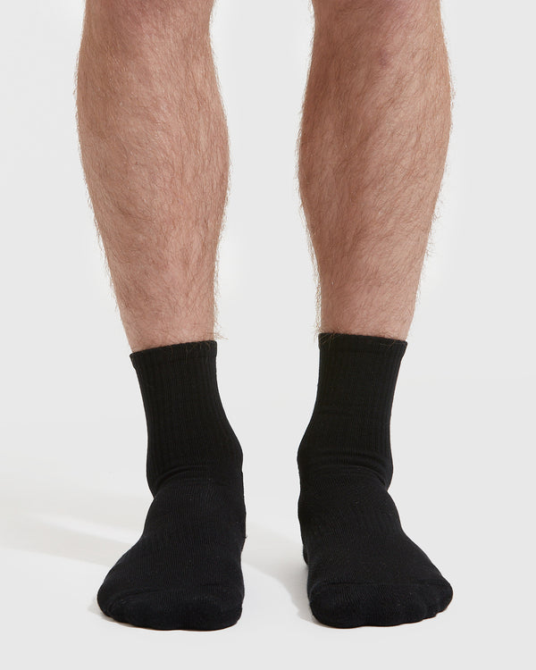 Black Half Crew Socks 3-Pack on legs against white background.