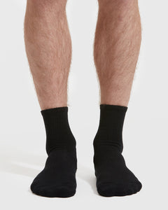 True ClassicBlack Half Crew Socks 12-Pack on legs, showcasing seamless toe and contour seam.