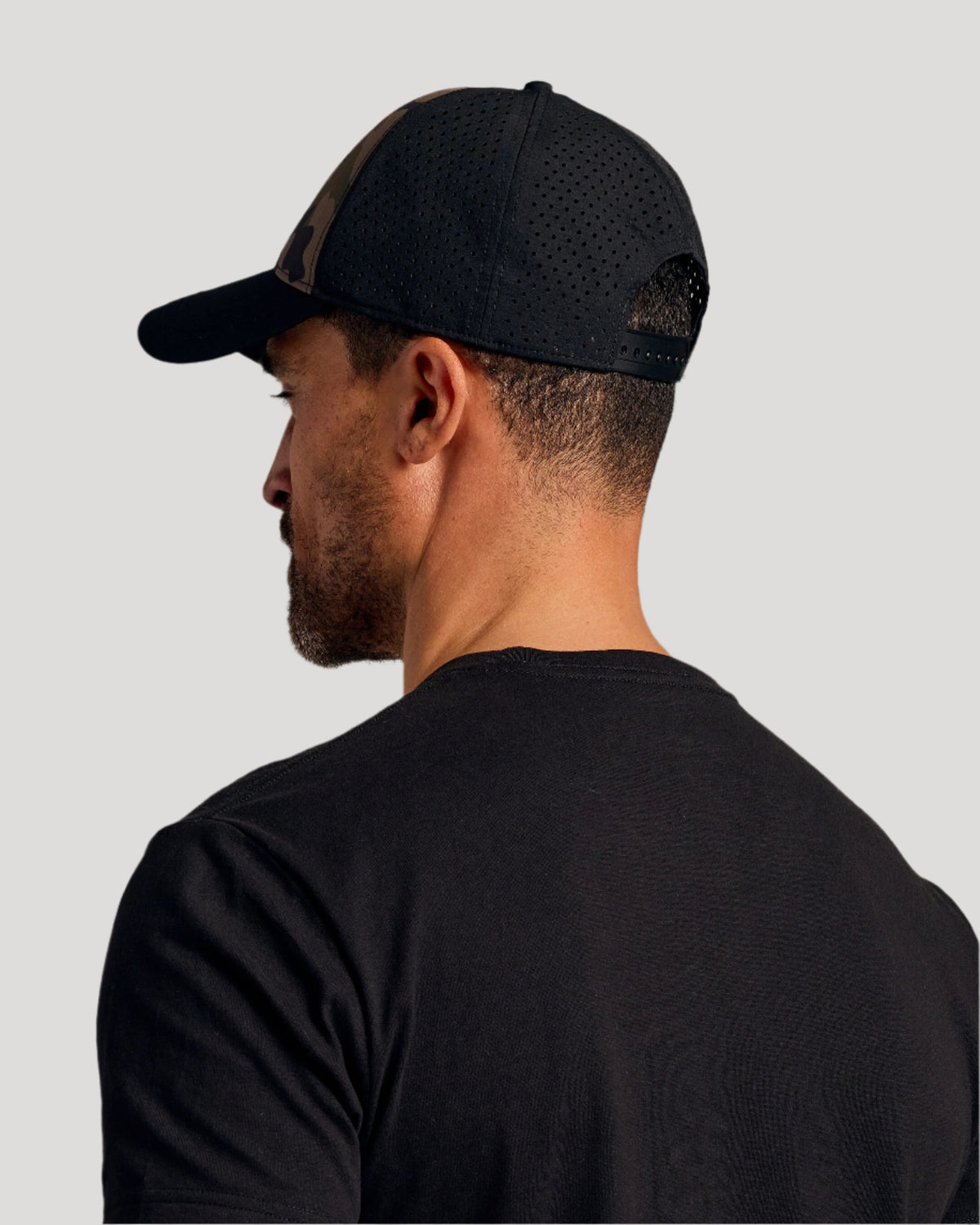 Man wearing Olive Camo All Purpose Cap, side profile visible.