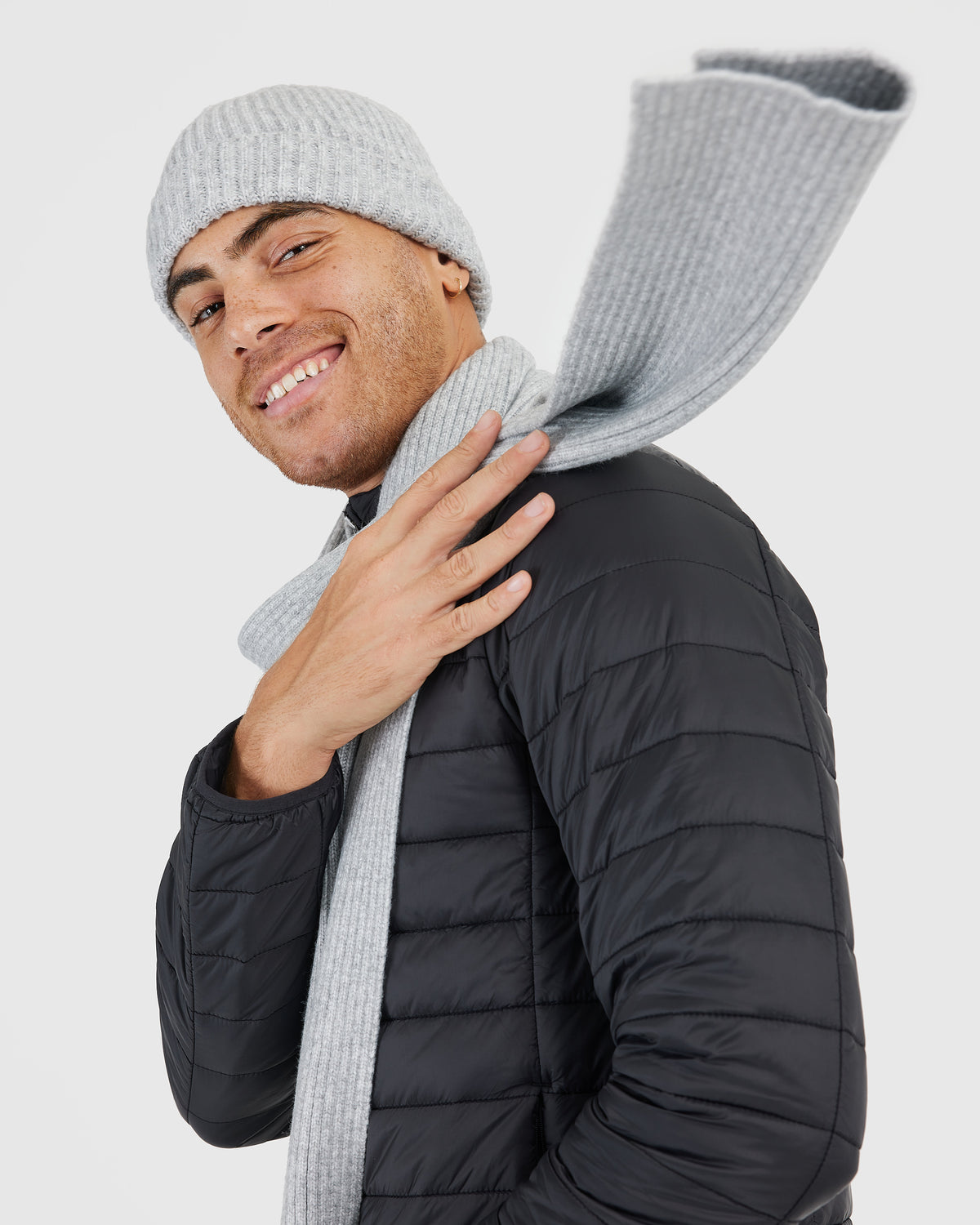 Person wearing Heather Gray Sweater Scarf with black quilted jacket.