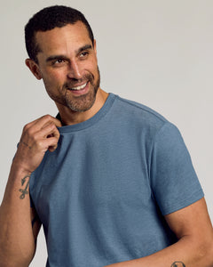 True ClassicMan wearing Dark Heather Tempest Classic Crew Neck, smiling, showcasing tattoos.