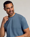 Man wearing Dark Heather Tempest Classic Crew Neck, smiling, showcasing tattoos.