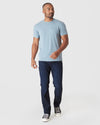 Man wearing Heather Sapphire Short Sleeve Crew Neck T Shirt, jeans, and sneakers.