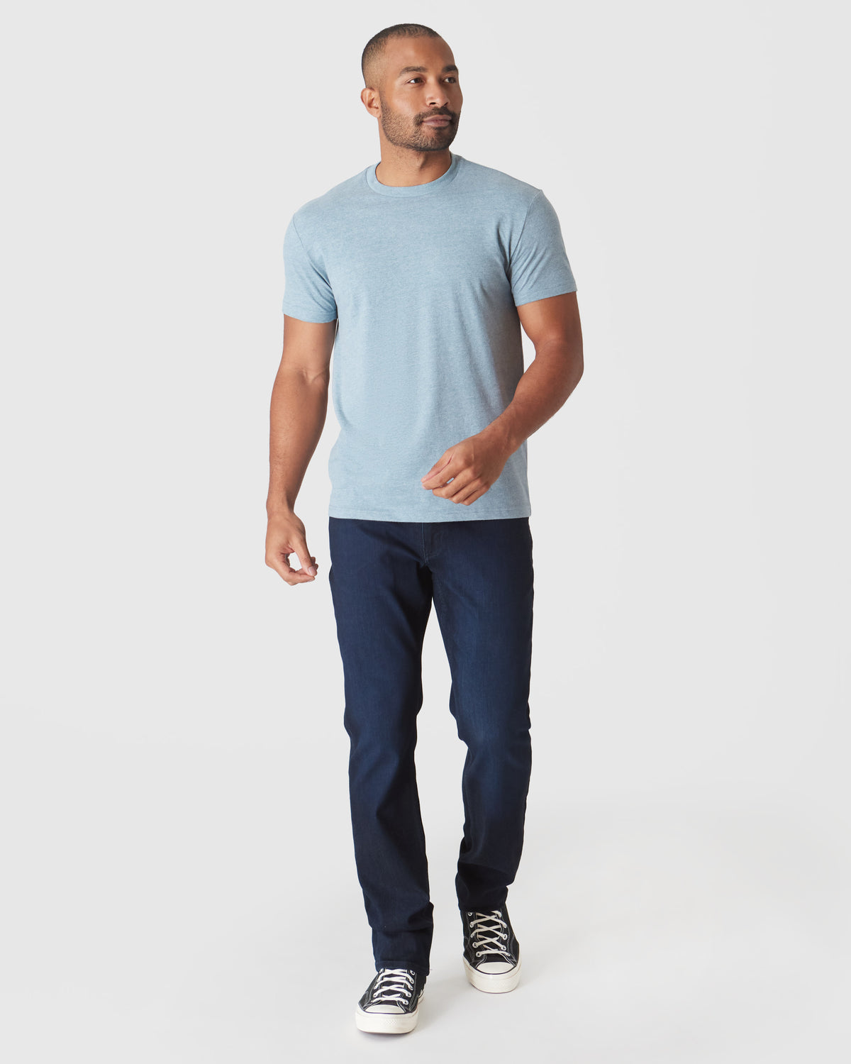 Man wearing Heather Sapphire Short Sleeve Crew Neck T Shirt, jeans, and sneakers.