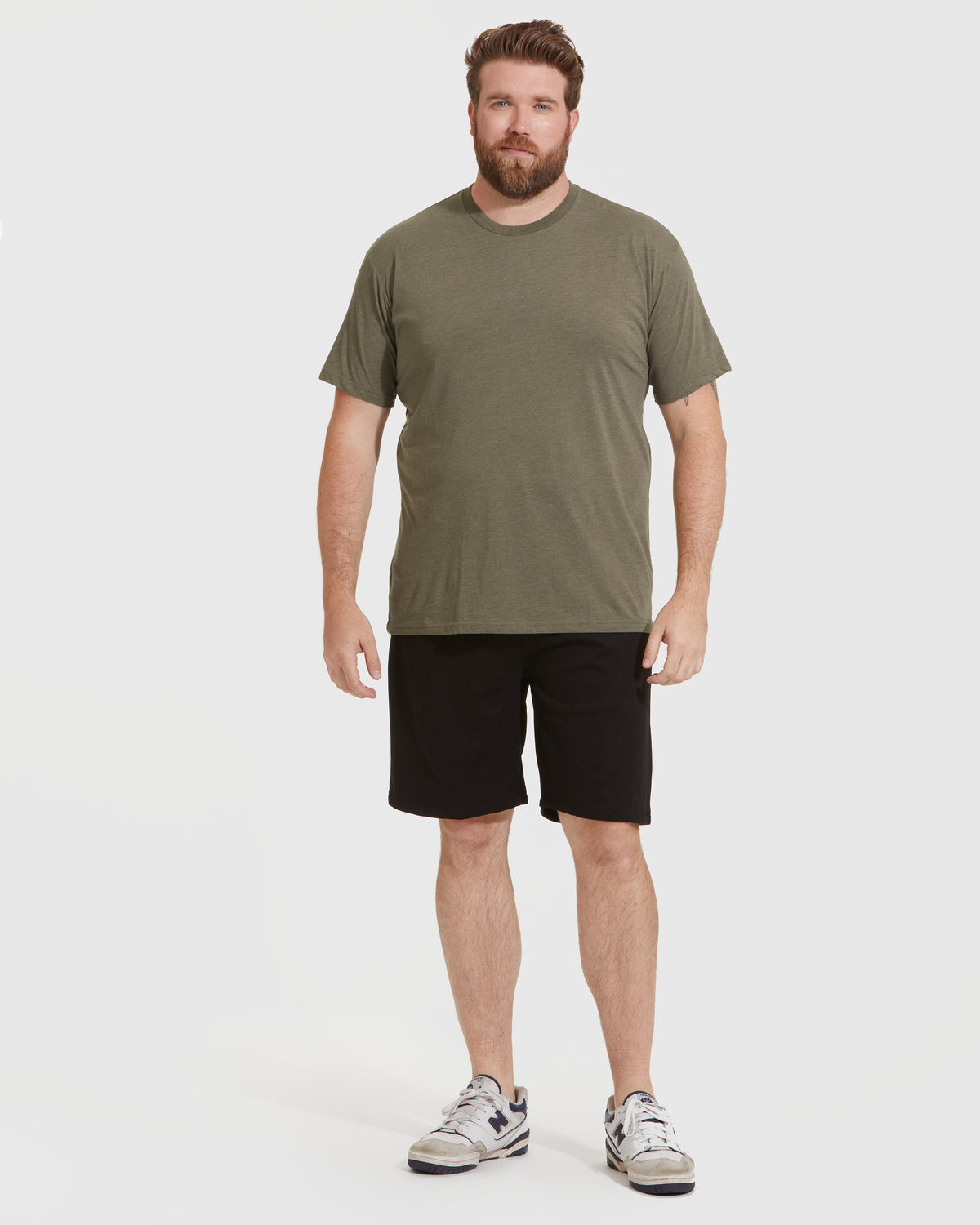 Man wearing Classic Crews 6-Pack: olive-green T-shirt, black shorts, white sneakers.