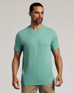 Man wearing Light Heather Greenery Classic Crew Neck and tan pants.
