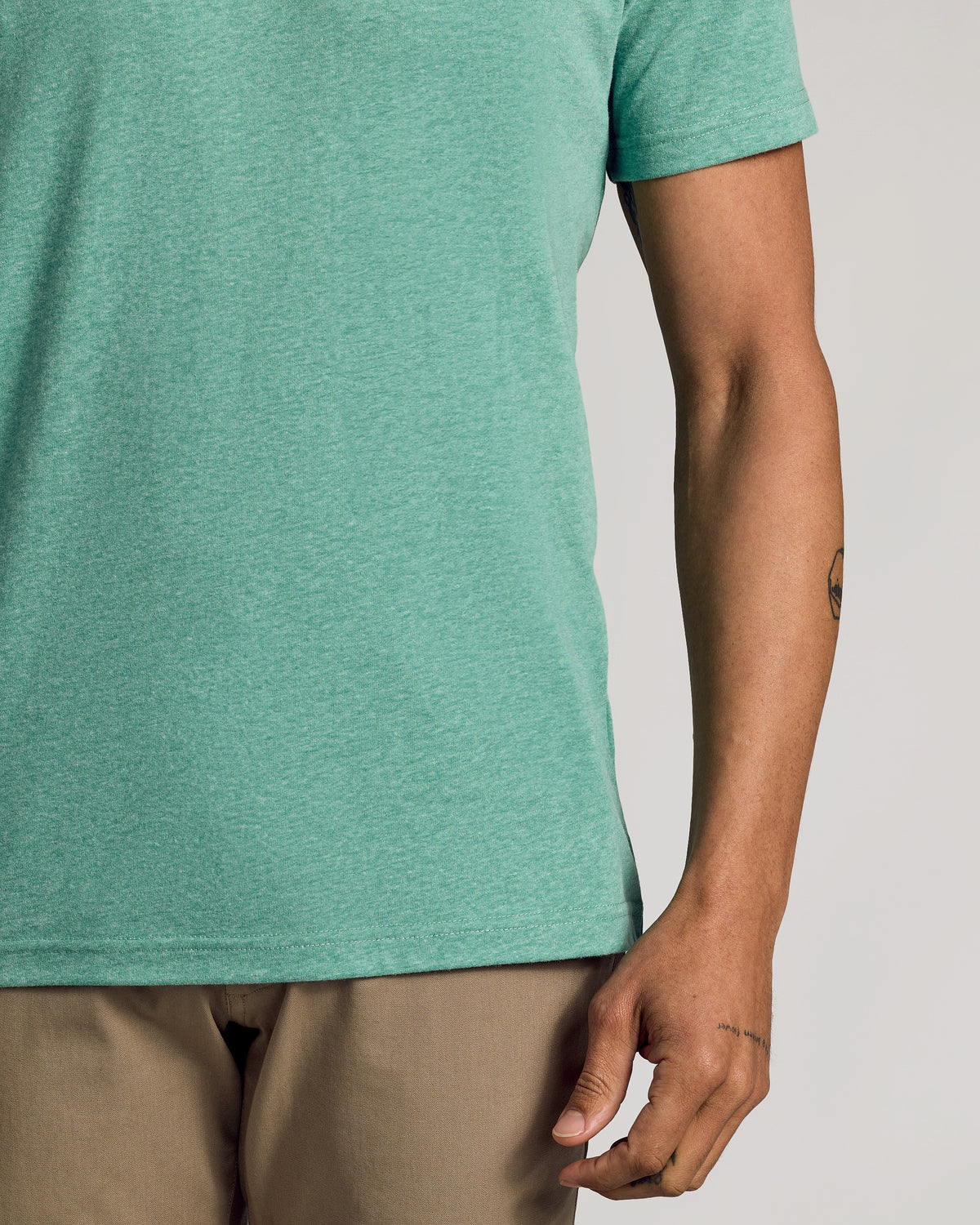 Light Heather Greenery Classic Crew Neck worn with khaki trousers.