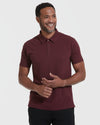 Man in Mahogany Polo, hands clasped, against light background.