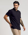 Man modeling Black Classic Polo with khaki pants, showcasing tattoos.