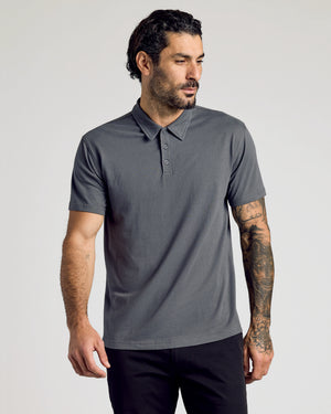 Man in Carbon Classic Polo with tattoos on right arm.
