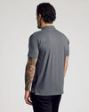 Man wearing Classic Polo from 6-Pack, back view, tattooed arm visible.
