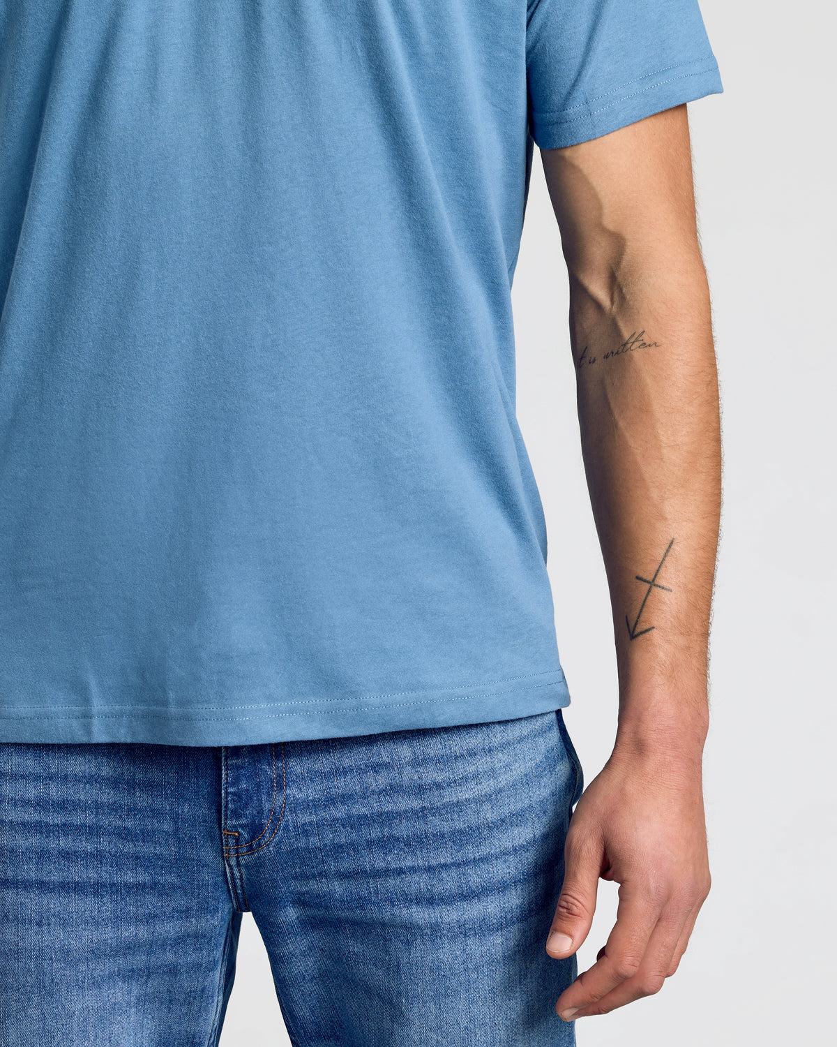 Person wearing Indigo Classic Polo, arm showing tattoos.