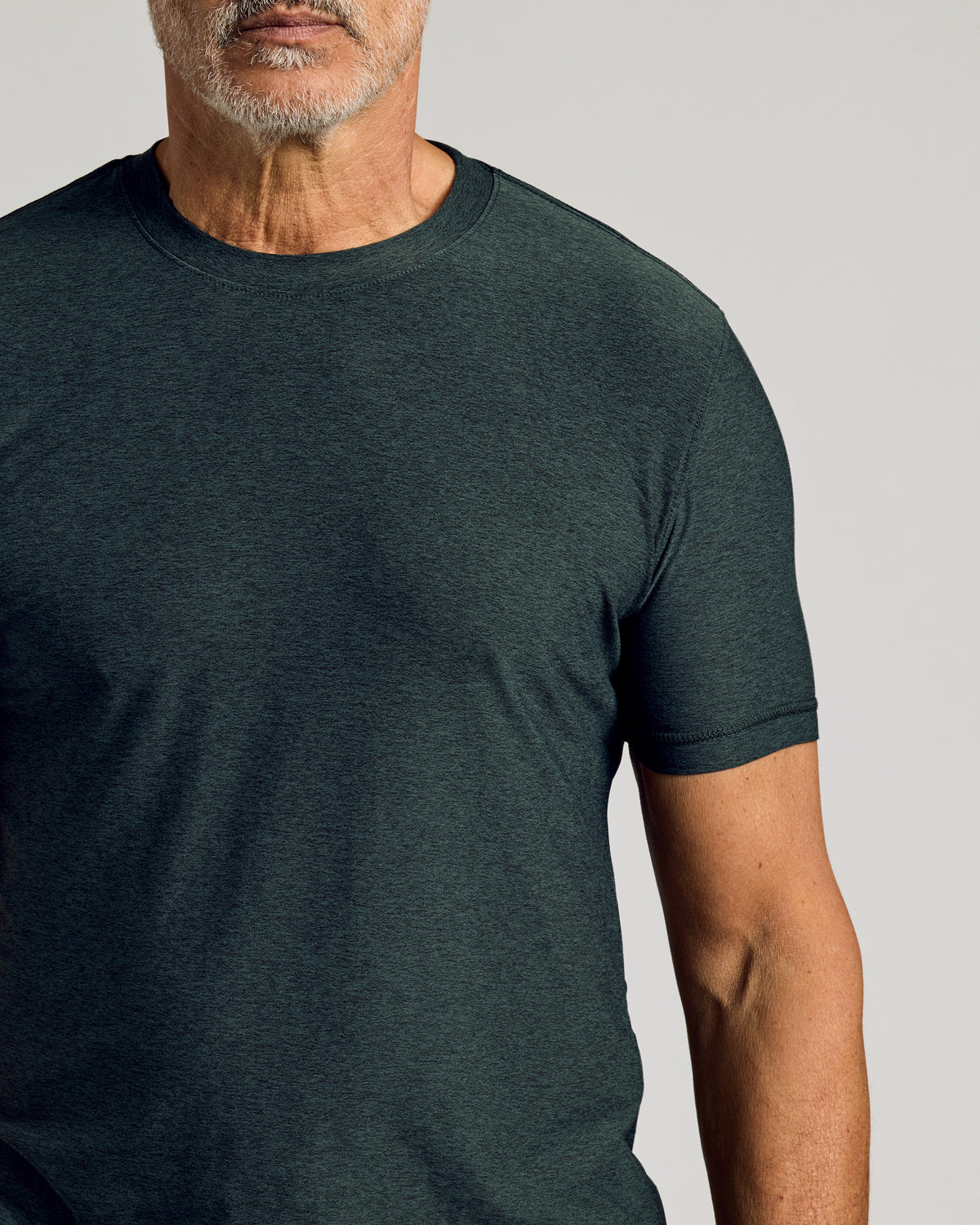 Man wearing Dark Heather Forest Active Short Sleeve Crew Neck Tee.