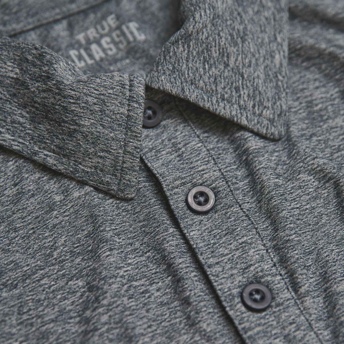 Heather Navy Short Sleeve Active Polo with three-button placket and collar.