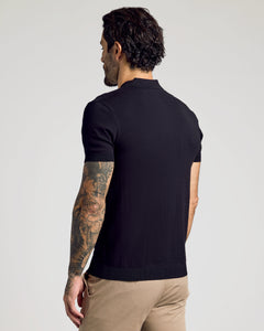 True ClassicMan wearing a Black Short Sleeve Sweater Polo, showcasing tattoos.