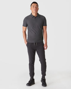 True ClassicMan wearing Dark Heather Tempest Active Polo 2.0 with black joggers.
