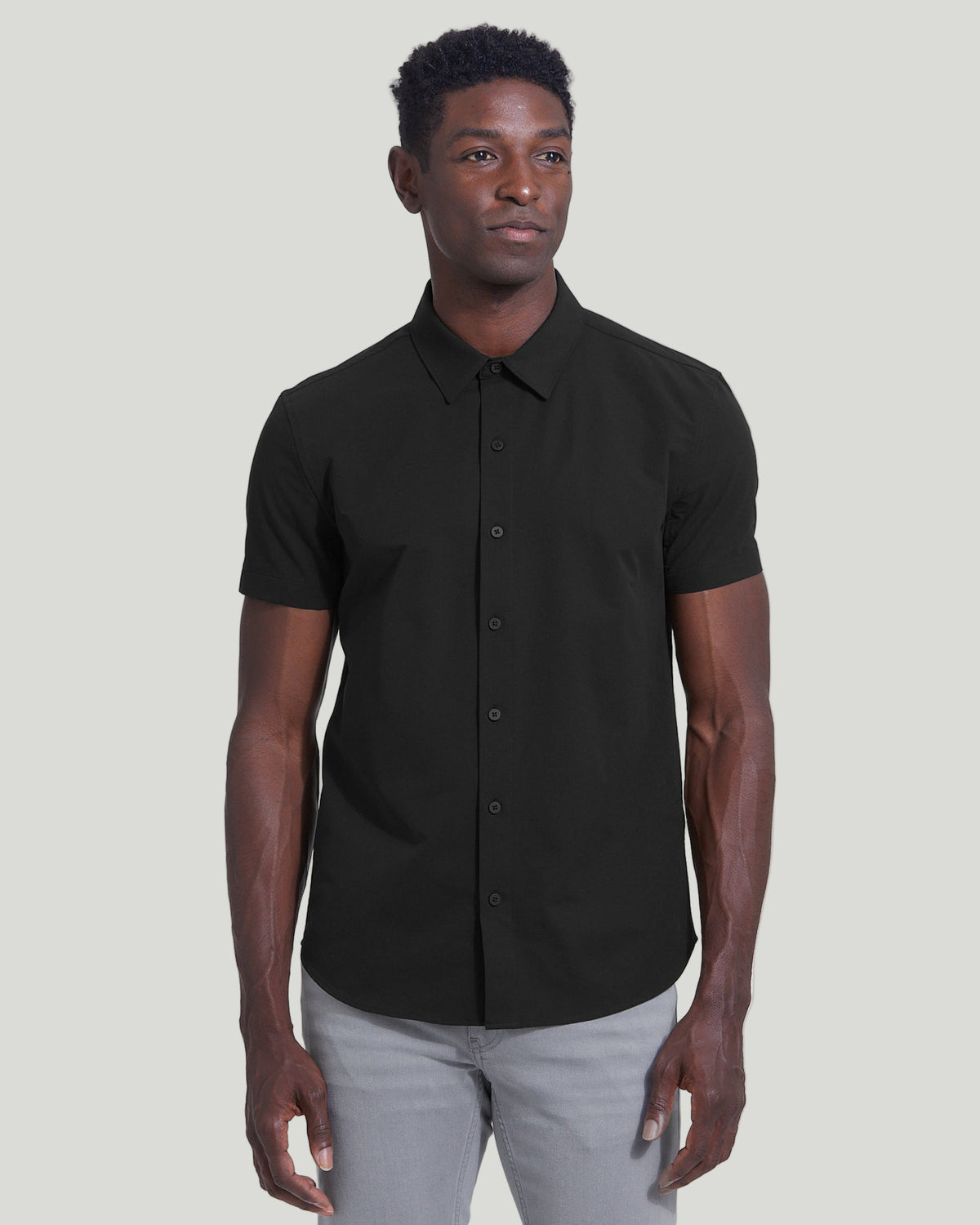 Man wearing Black Commuter Short Sleeve Shirt with light gray pants.
