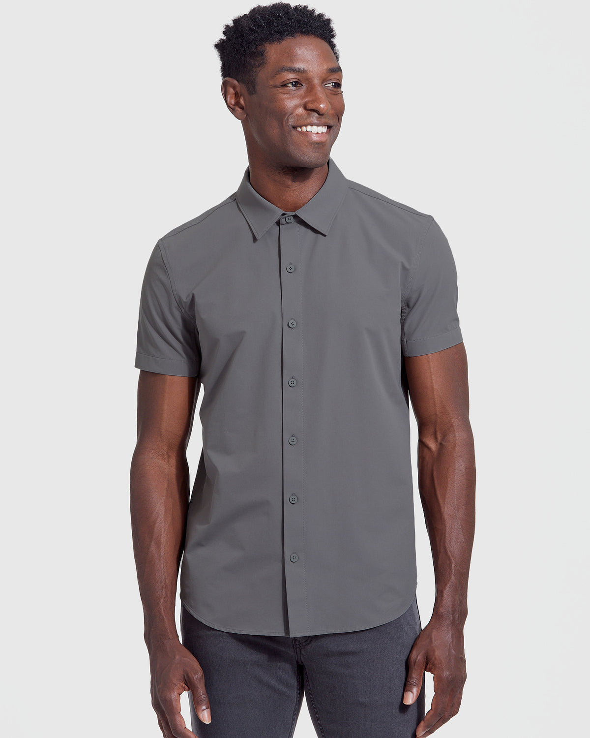 Model in Carbon Commuter Short Sleeve Shirt, slate-gray, smiling slightly.
