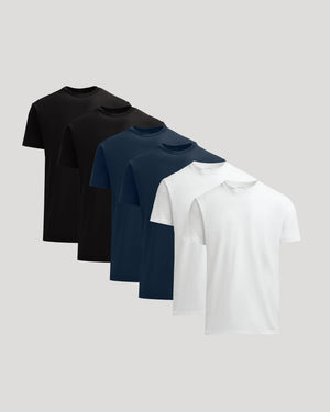 Three black, one navy, and one white t-shirt on a light gray background