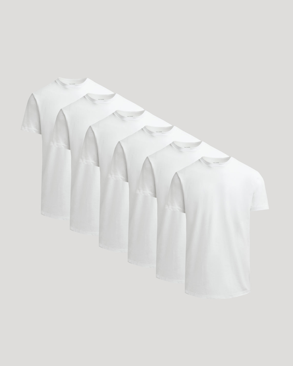 Six plain white crew neck t-shirts displayed side by side showcasing the True Classic Men's Heavyweight Curved Hem Crew – Premium Heavyweight Cotton Blend, Modern Athletic Fit, Structured Everyday T-Shirt in men's basics.