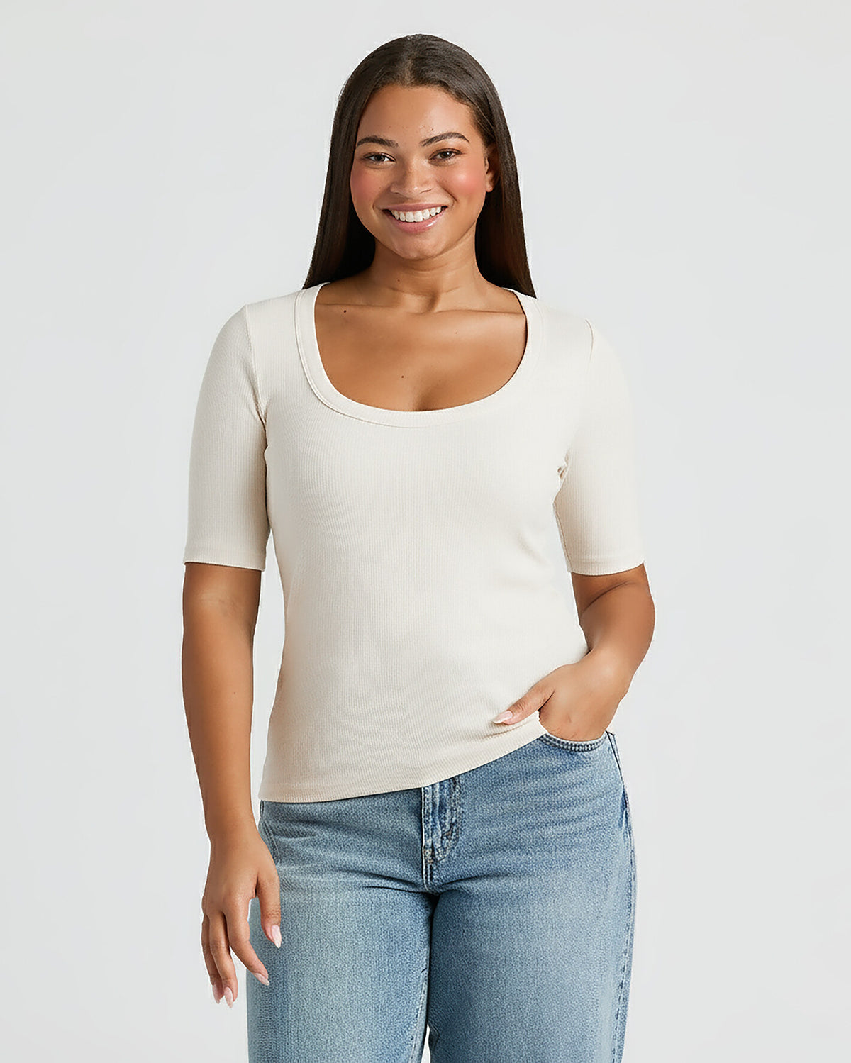 Woman wearing a white t-shirt and blue jeans on a plain background. MODEL_INFO: Jade is 5'9", wearing a size L