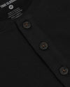 Close-up of a black heavyweight henley shirt showing button details and ribbed neckline, part of the All Black Heavyweight Curved Hem Henley 3-Pack men's basics by True Classic.