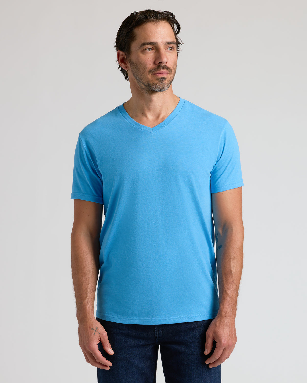 Man wearing Dark Heather Bahama Blue Classic V-Neck and dark jeans.