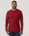 Man wearing a crimson long sleeve crew neck shirt, posing against a plain gray background, showcasing a men's basics style.