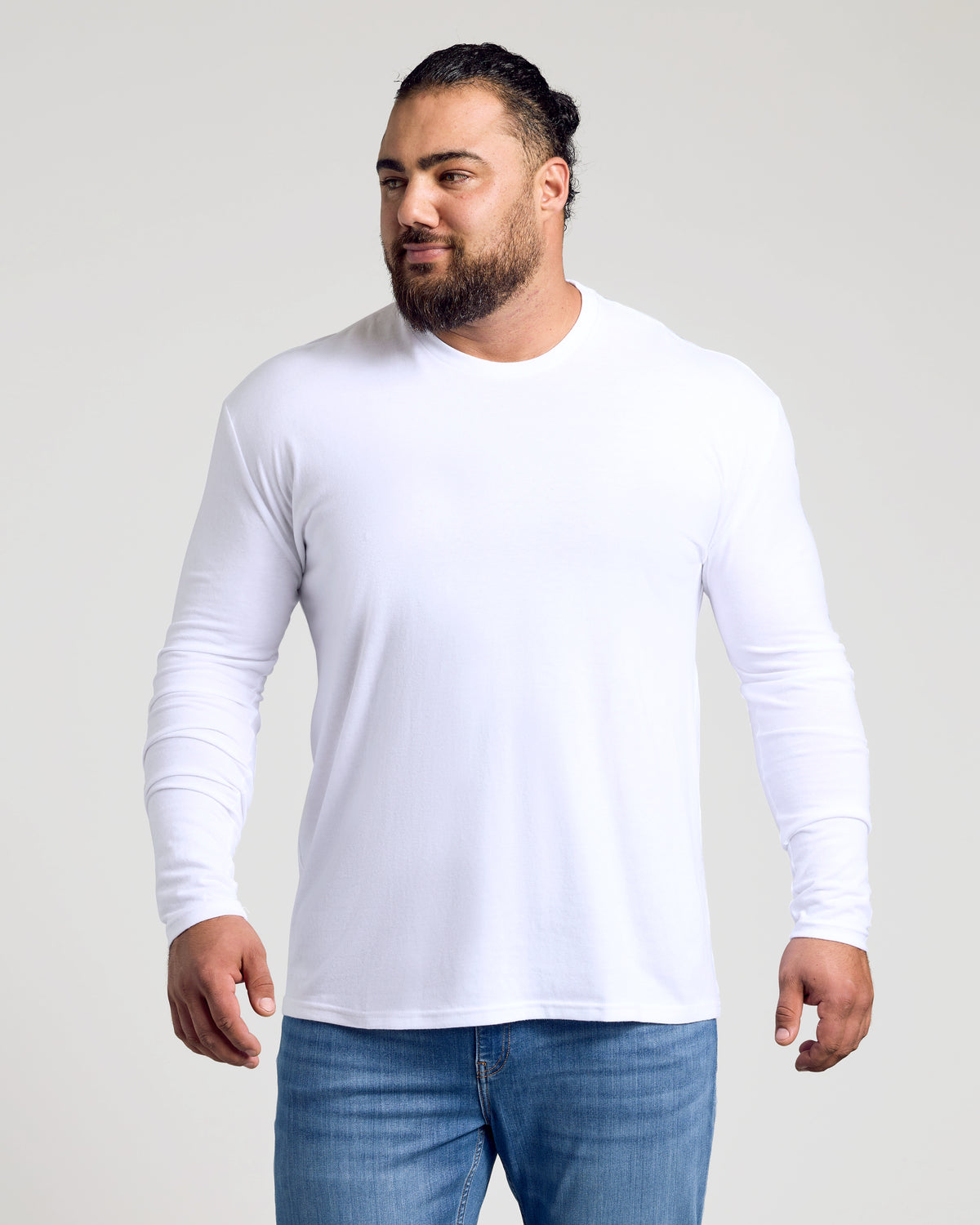 Man wearing White Classic Long Sleeve Crew Neck and blue jeans.