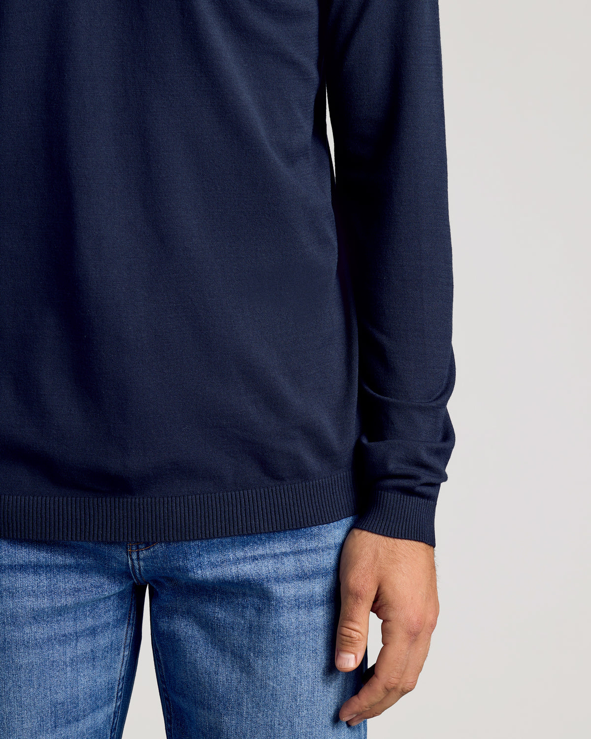 Person wearing Black & Navy Crew Neck Sweater over blue jeans.