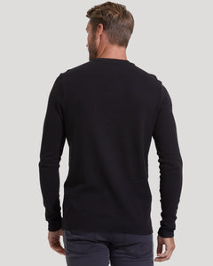 True ClassicBack view of a man wearing a Black Waffle Long Sleeve Crew Neck shirt, showcasing its fitted style and textured fabric in a casual men's basics look.