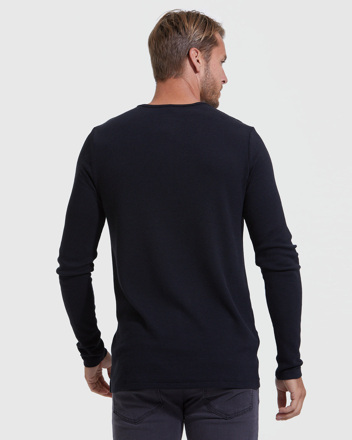 Black Waffle Long Sleeve Henley worn by man, back view.