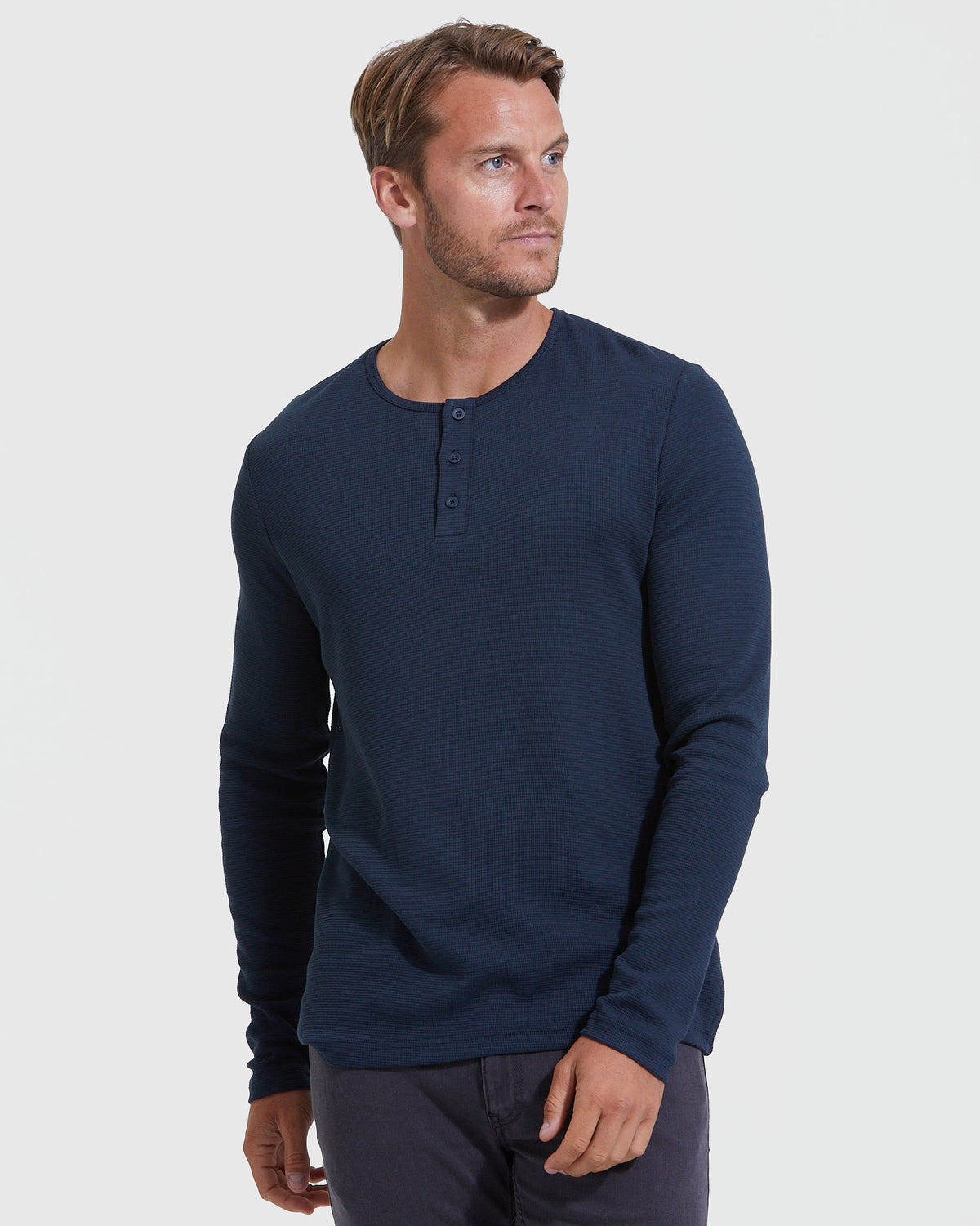 Man wearing The Staple Long Sleeve Henley 3-Pack in navy.