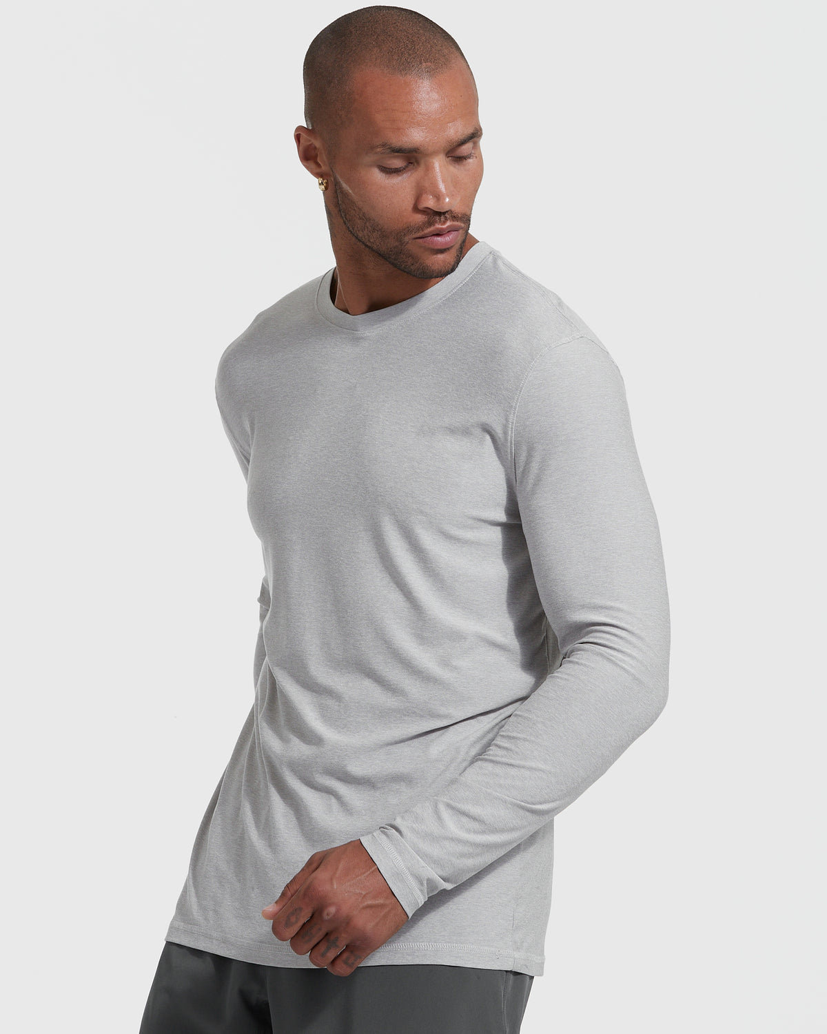 Man wearing Heather Light Gray Active Long Sleeve Crew T-Shirt against light background.