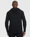 Black Active Hoodie worn by person, hood down, showcasing sleek fit and design.