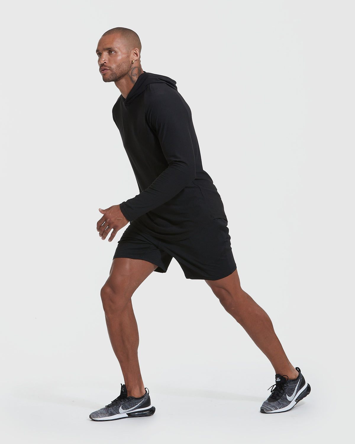 Man wearing Black Active Hoodie, poised to sprint.