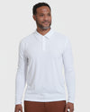 Man wearing White Long Sleeve Polo with brown trousers.
