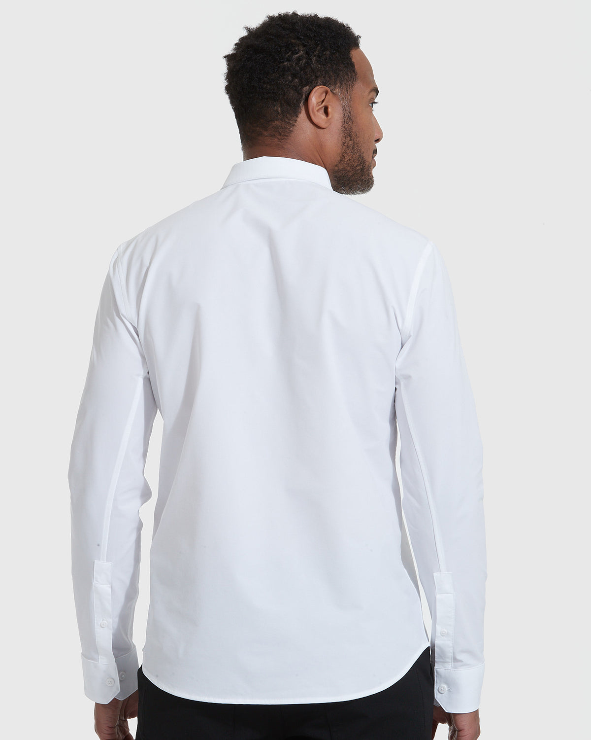 White Commuter Long Sleeve Shirt, back view, worn with dark trousers.