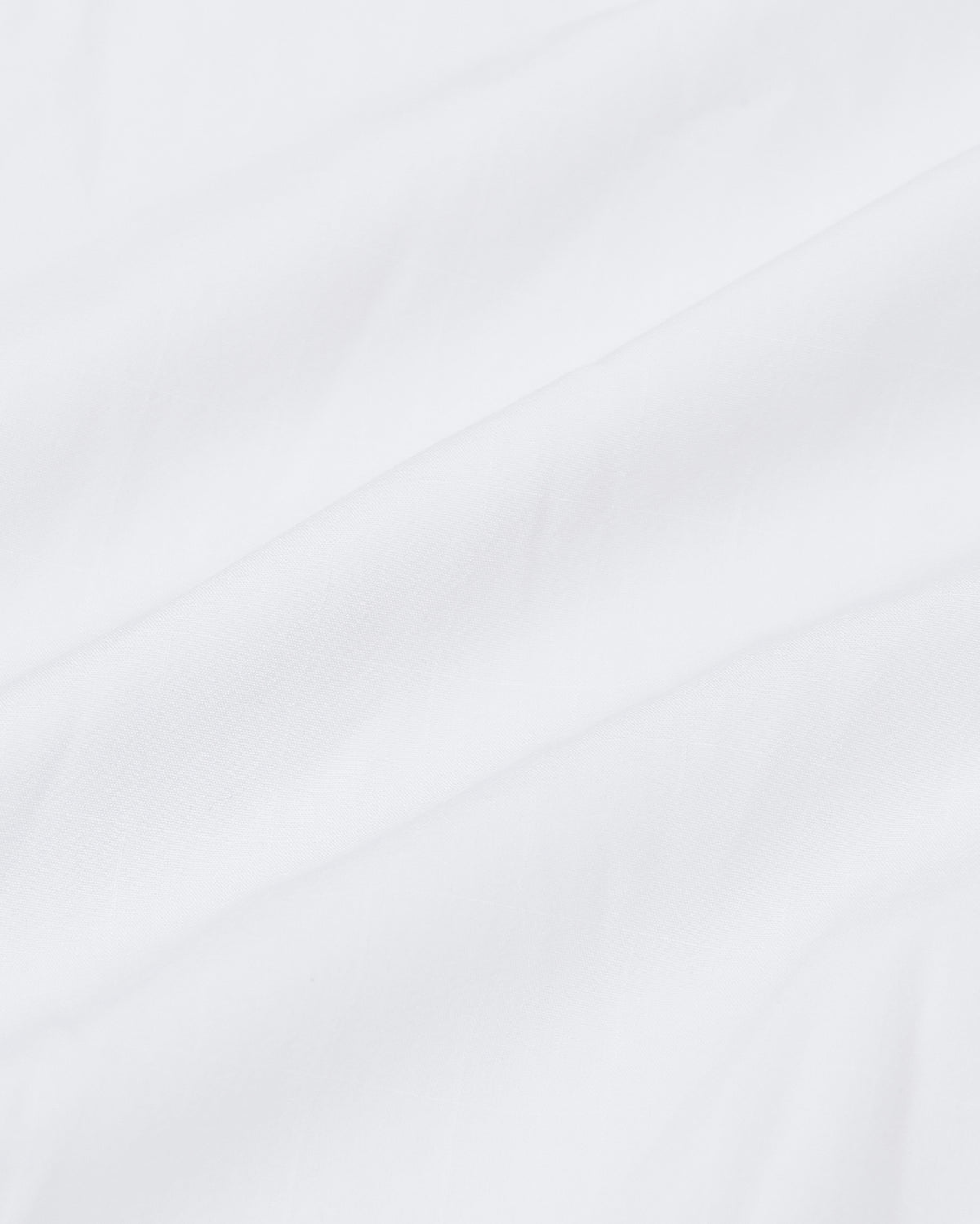White Lightweight Dress Shirt close-up with subtle fabric folds.