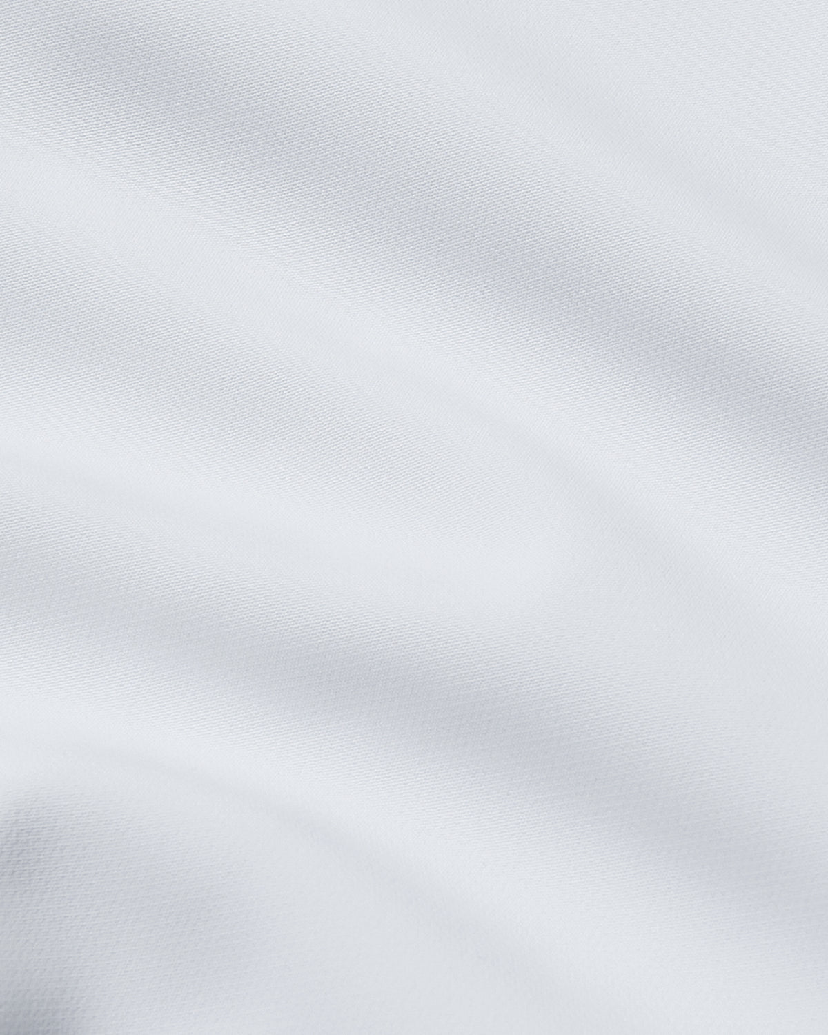 Close-up of smooth white fabric texture showcasing the material quality of the White Performance Long Sleeve Dress Shirt, ideal for men's basics and versatile wear.