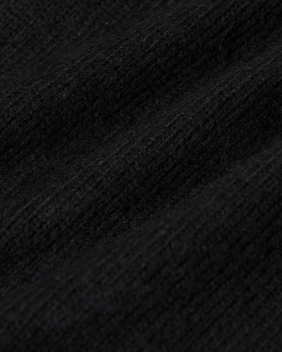 Black Crew Neck Sweater showcasing textured knit fibers and ribbed detailing.