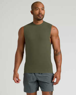 Man wearing Limited Sleeveless Active Muscle Tee in olive, showcasing tattoos and fit.