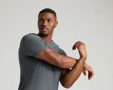 True ClassicCarbon Tall Active Crew Neck 2.0 worn by man stretching arms.