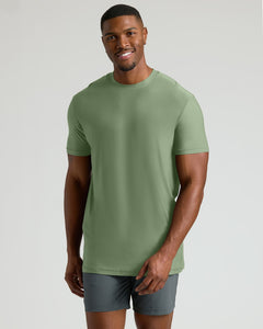 True ClassicSmiling man wearing a sage green short-sleeve shirt and dark gray shorts, modeling the Seasonal Tall Active Crew 3-Pack men's basics.