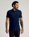 Man models Timeless Tall Active Polo in navy, short-sleeve, tattooed arm visible.