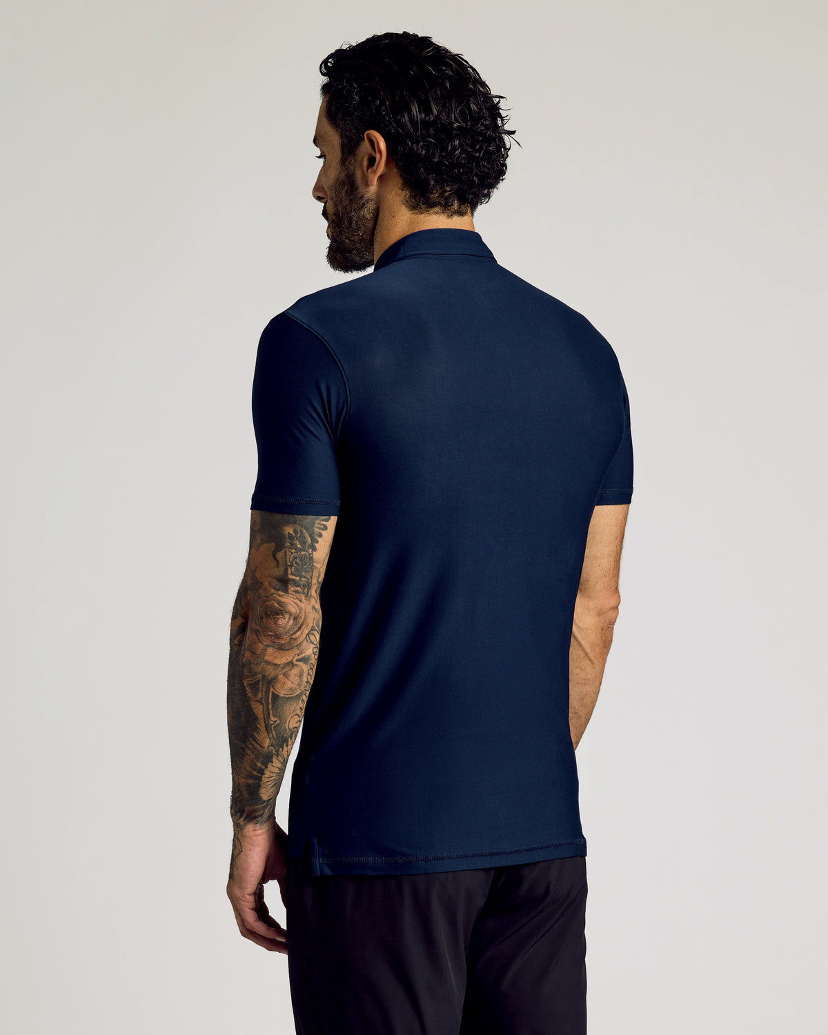 Man in Navy Short Sleeve Tall Active Polo, showcasing tattooed arm.