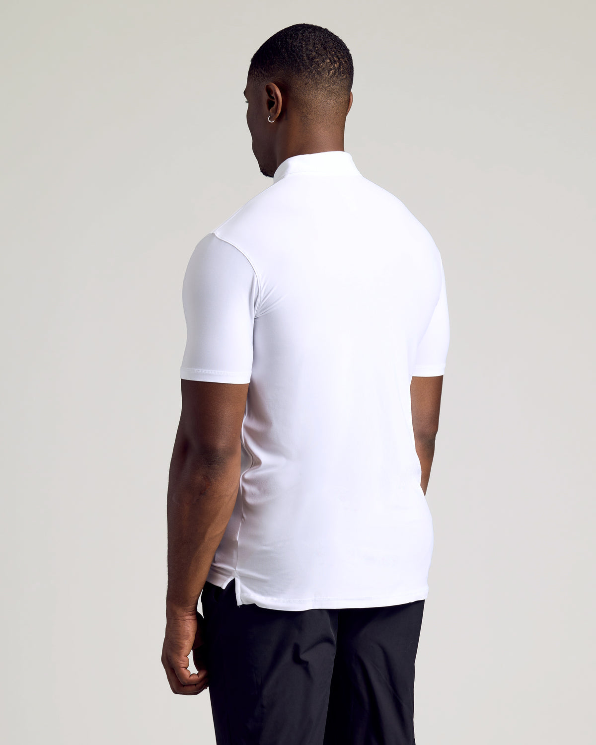 Man wearing White Short Sleeve Tall Active Polo, standing from behind.