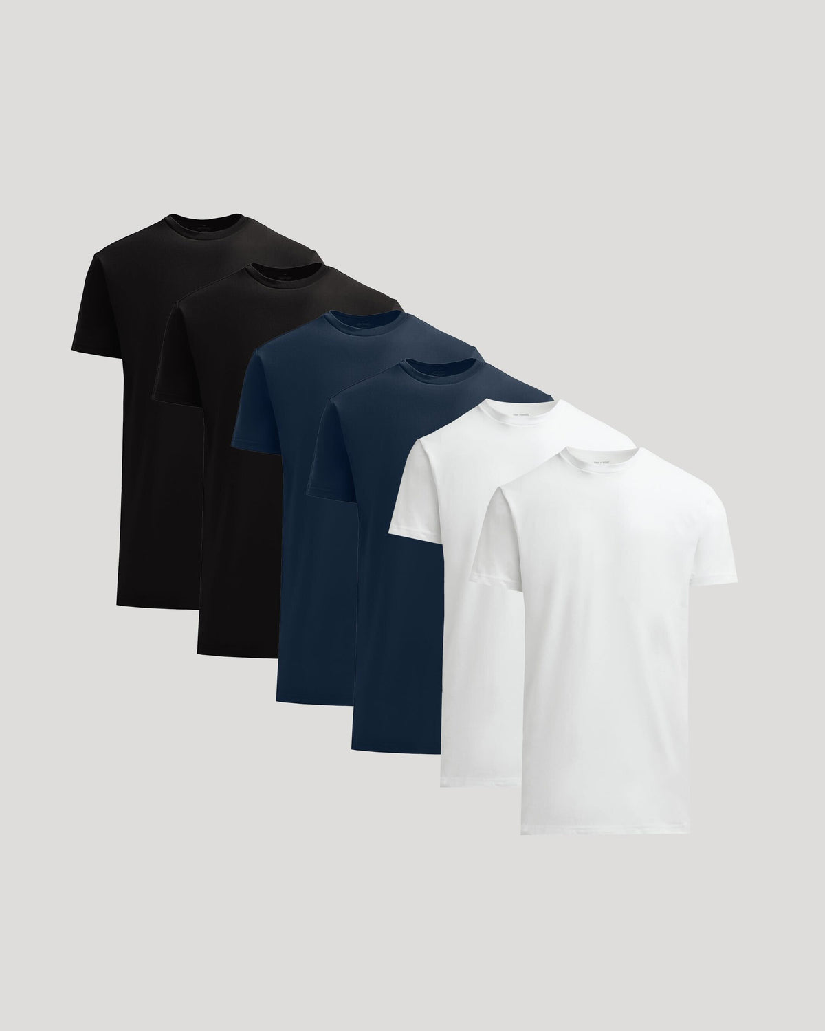 Four t-shirts in black, navy, and white on a light gray background