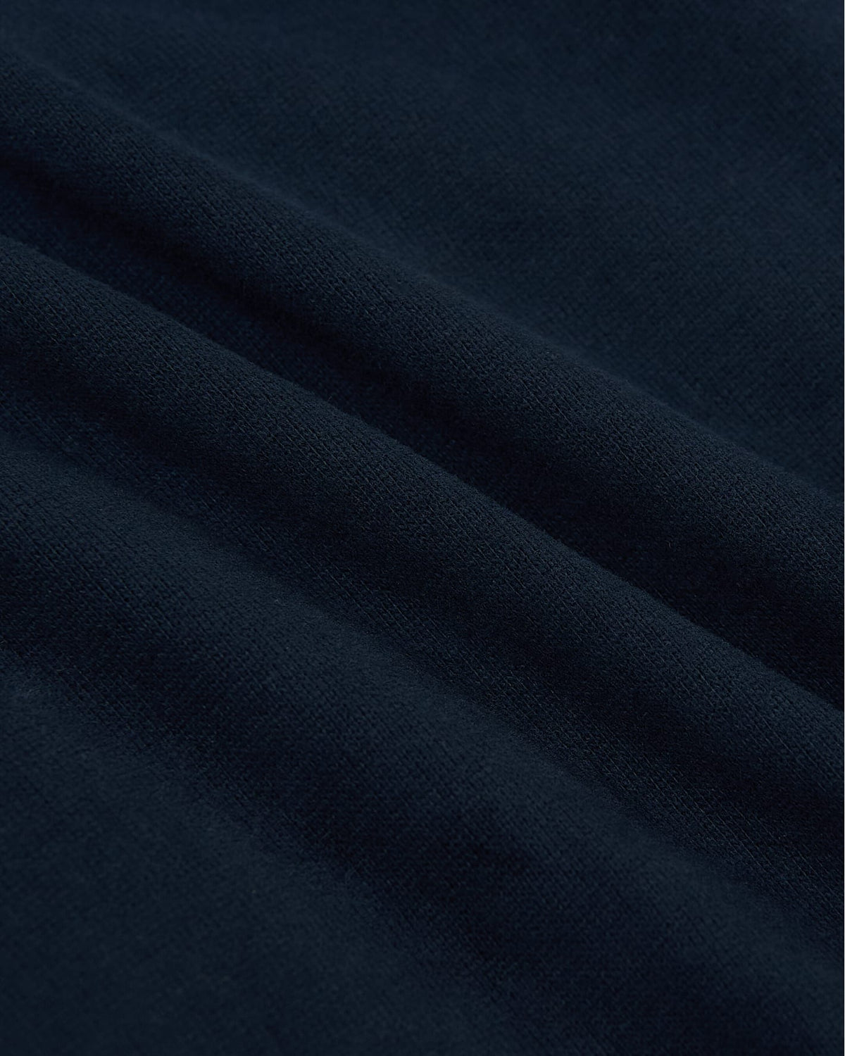 Close-up of soft navy fabric texture showcasing the heavyweight material of the Navy Tall Heavyweight Curved Hem Crew, a comfortable essential in men's basics.